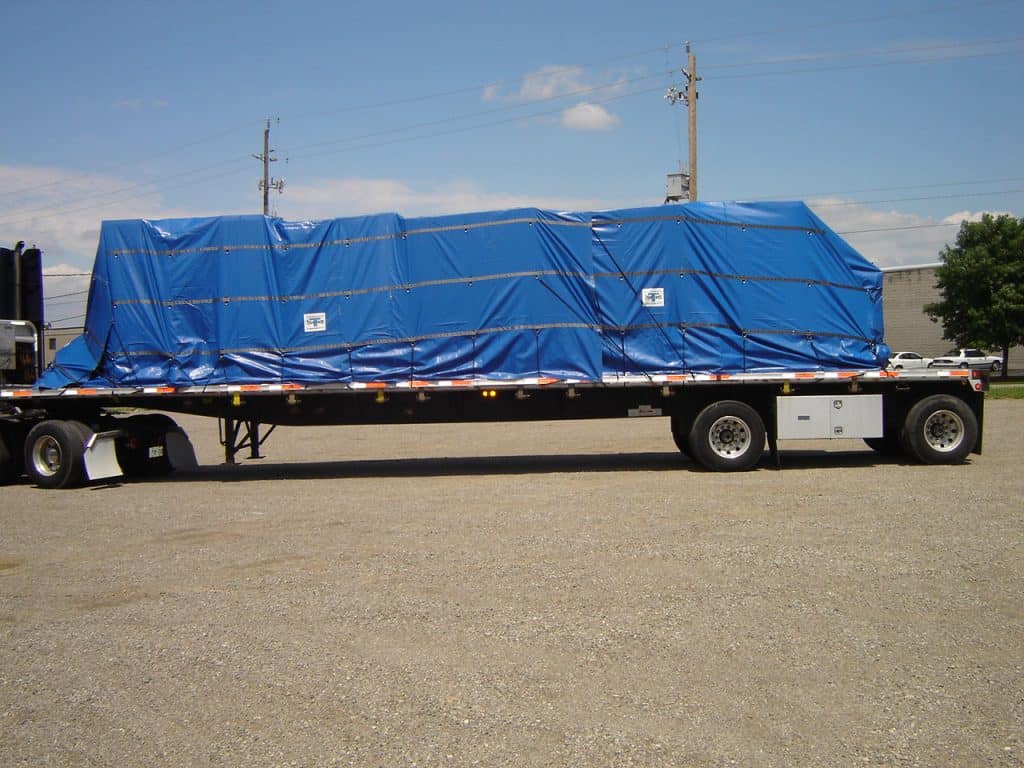 Trison 2 piece Lumber Tarp set on flatbed trailer pulled by blue truck