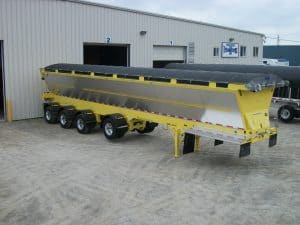 Black Mesh Trison Cable System Tarp on yellow Trail King Red River live bottom trailer